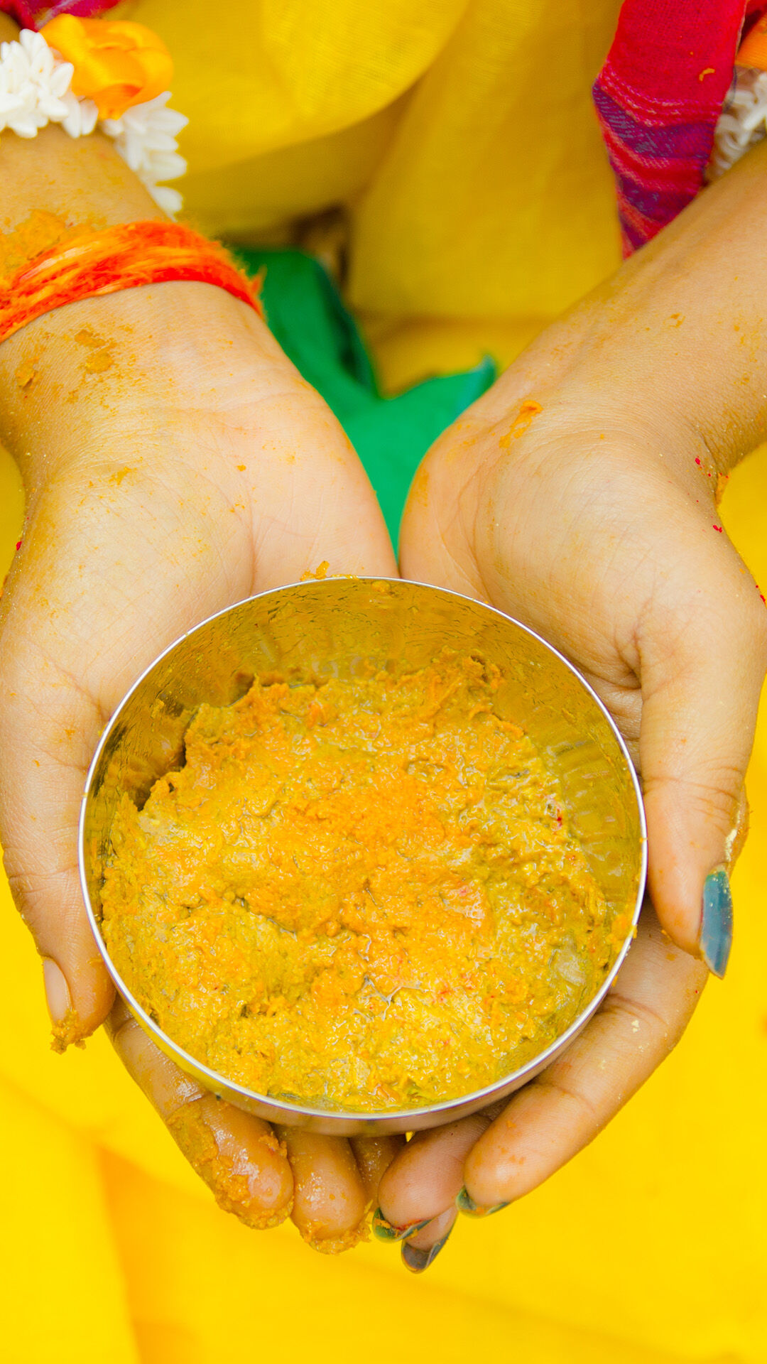 A women holding haldi bowl on haldi ceremony